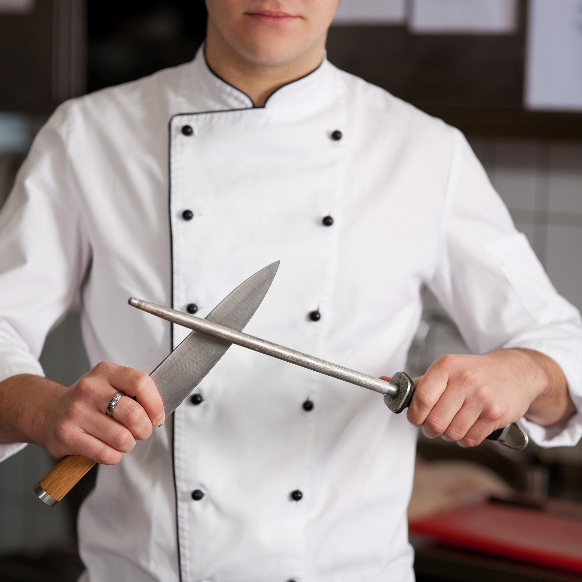 Chef demonstrating knife technique to student